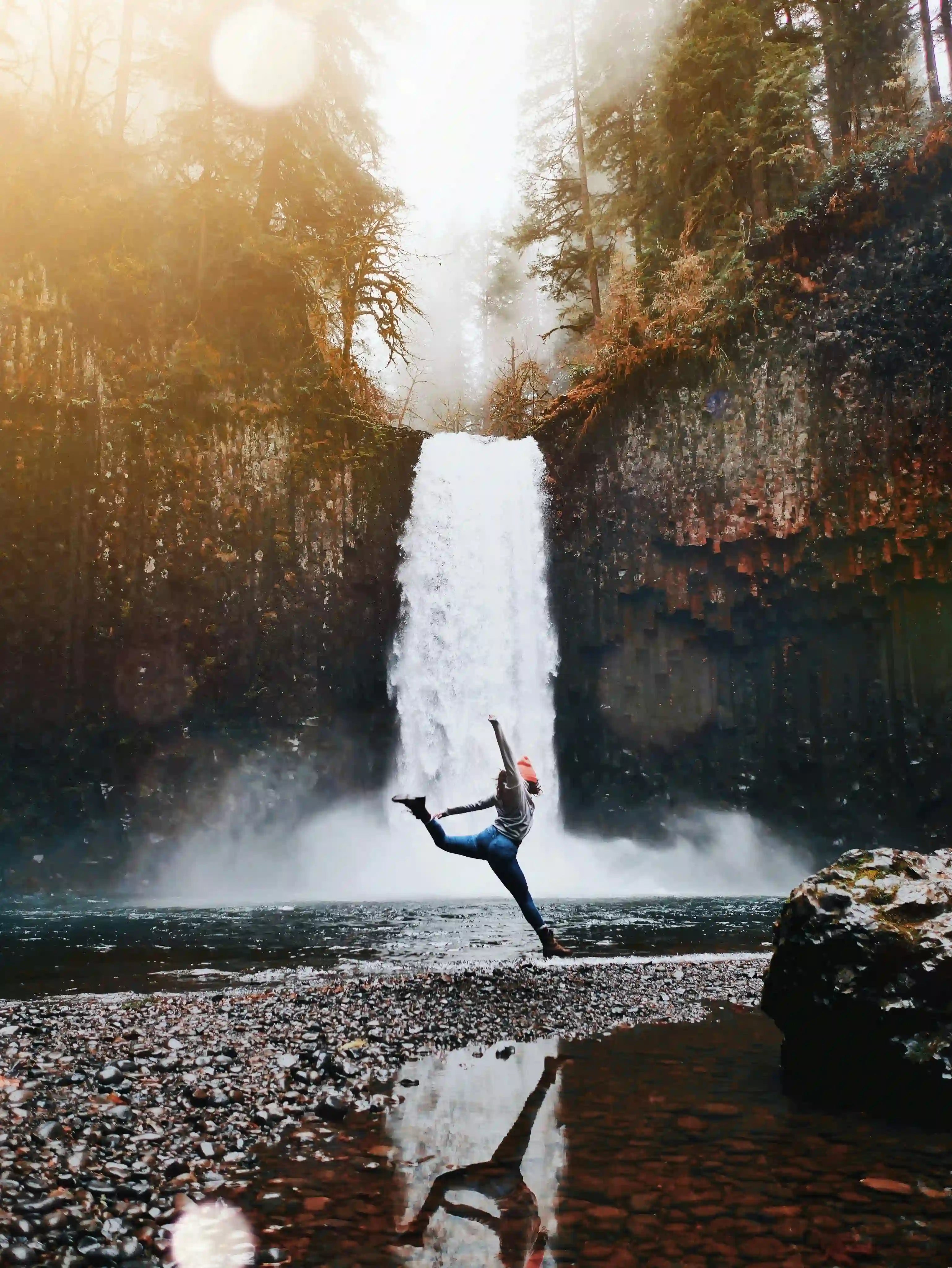 Frau macht Yoga vor Wasserfall